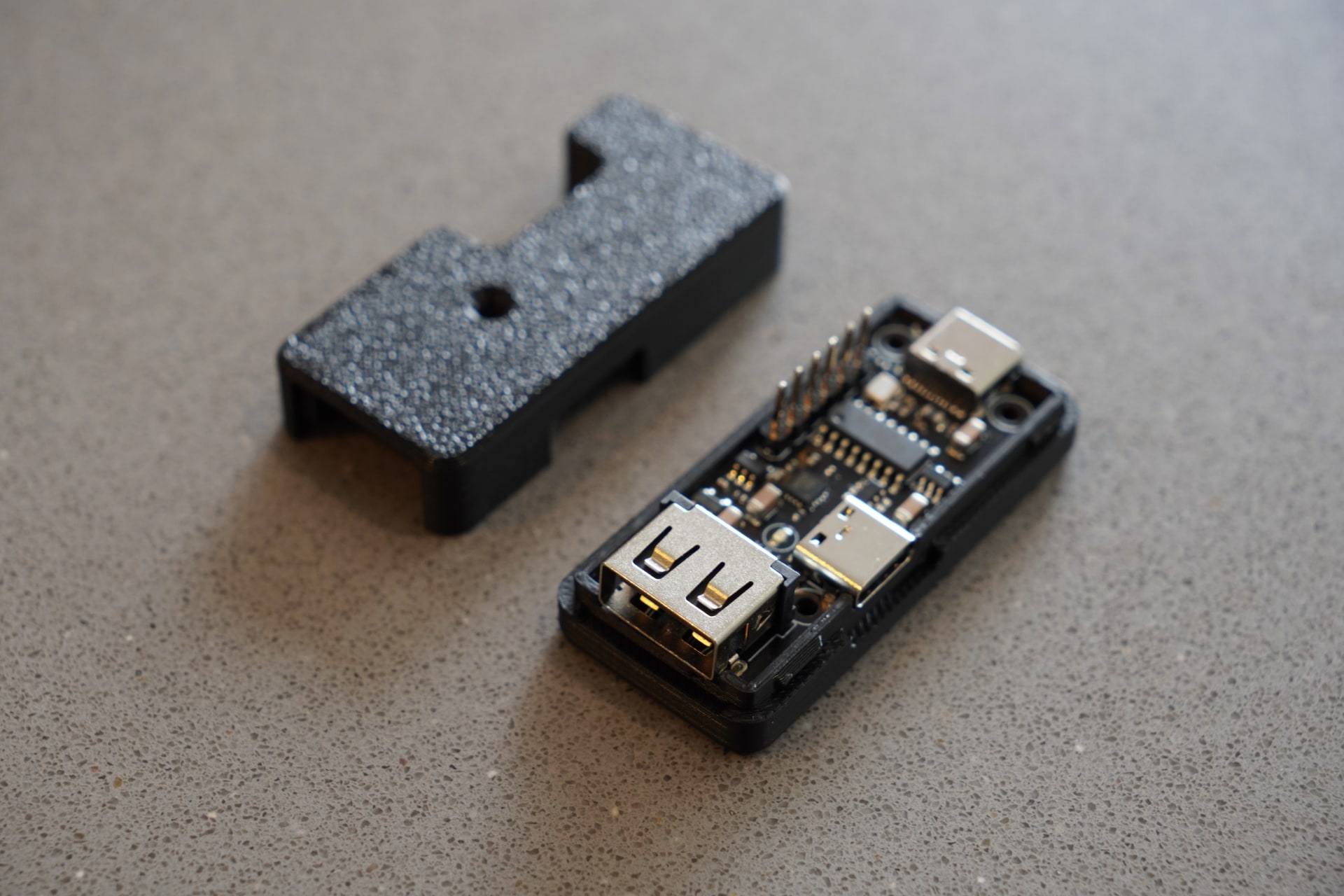 pt1 seated in the lower half of its 3D-printed case beside the removable lid
